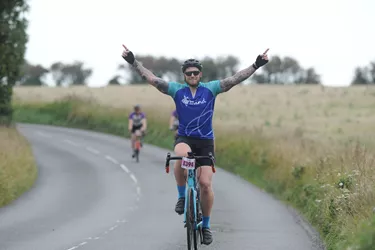 Happy male cyclist taking part in a road event